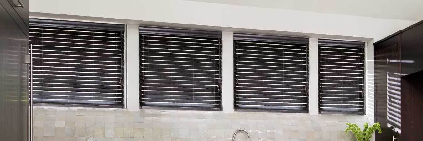 Dark brown wood blinds on kitchen windows